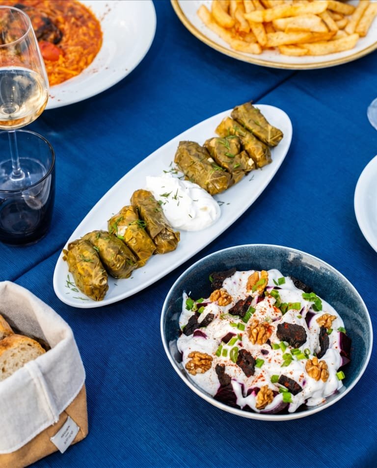 Dolmades with yogurt served as part of a Greek meze table.