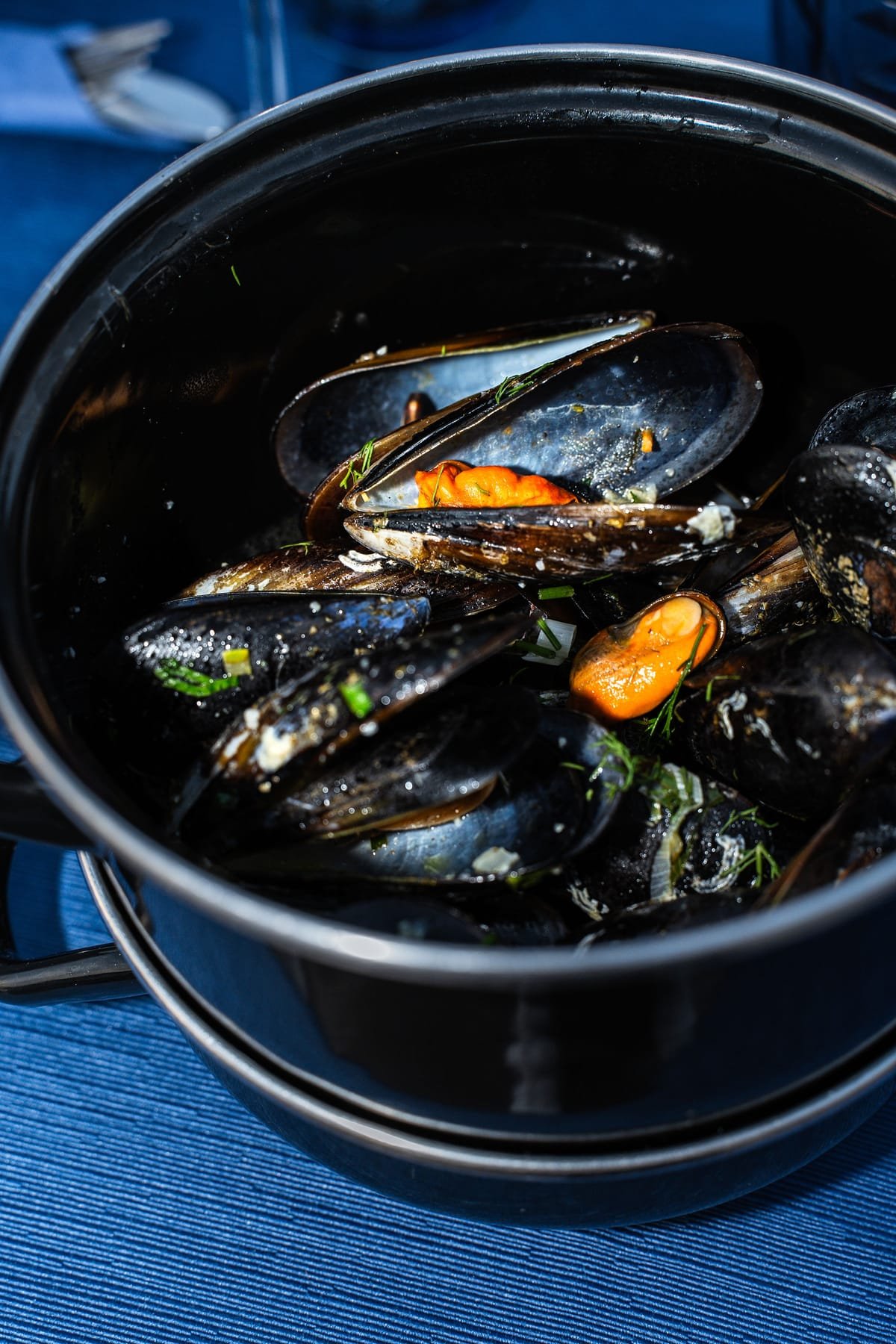 Close-up of mussels served in a pot with herbs at Sti Rota.