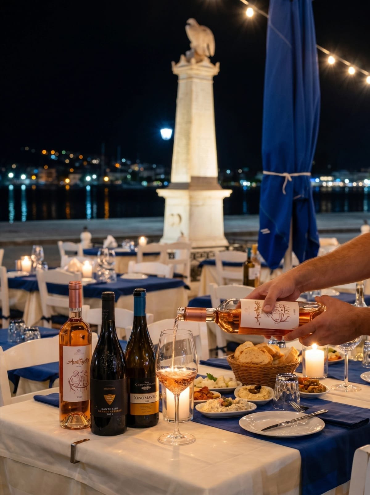 Rose wine being poured at night beside the Poros waterfront.